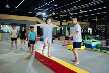 Asian coach instructing young kids