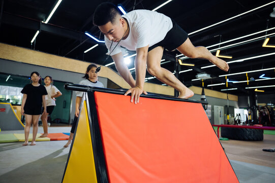 Asian coach instructing young kids