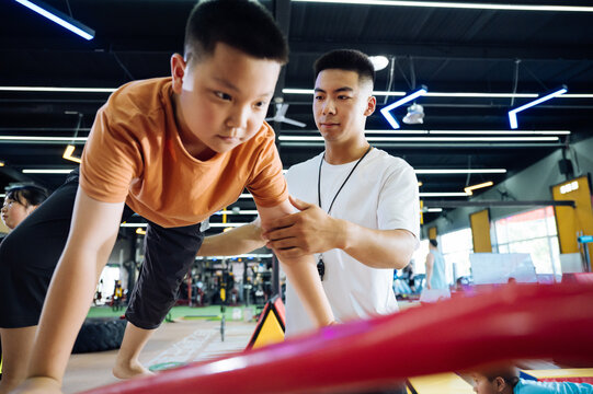 Asian coach instructing young kids