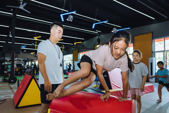 Asian coach instructing young kids