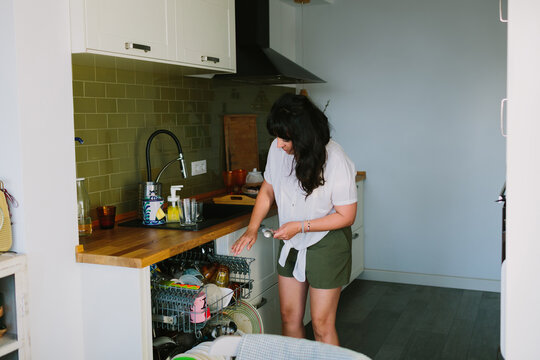 Young Woman Using The Dishwasher