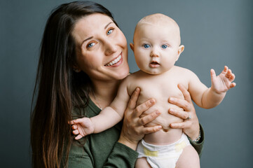 A smiling mother with her baby boy in her lap