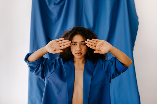Charming woman with hands near face in studio