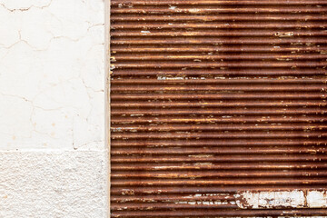 texture pattern of rusty iron door of closed store and white grunge wall in Brazil