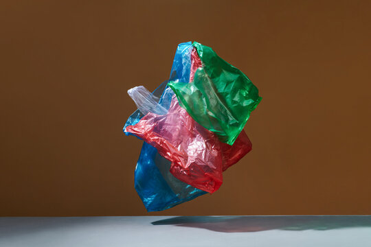 Colorful plastic bags hovering on brown background