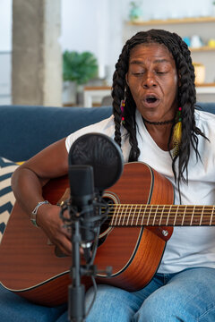 Old black lady Playing Guitar At Home 