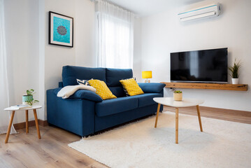 White living room with blue sofa and white carpet