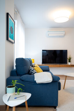 White living room with blue sofa and turquoise poster