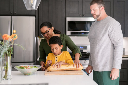 Tween son cutting bread and parents caring him