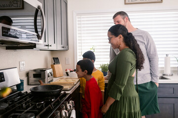 Family of four looking at the baked tray