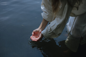 
female hands on the surface of the water