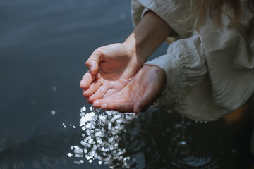 
female hands on the surface of the water