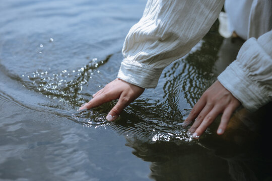 female hands on the surface of the water