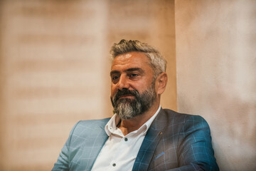 A modern senior businessman is sitting in a cafe and relaxing after a hard day's work