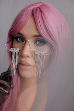 Beautiful woman with pink hair and glasses with crystal tears