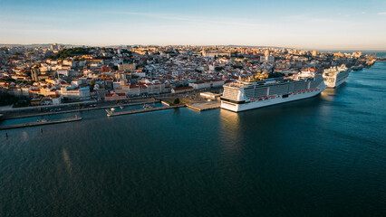 Fototapeta na wymiar aerial drone view of a large cruise ships moored at Lisbon port, Portugal with Lisbon landmarks in the background