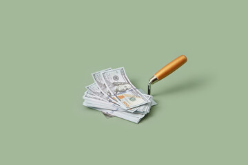 One hundred dollar bills on masonry trowel.