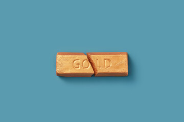 Broken golden bar with crack on blue background.