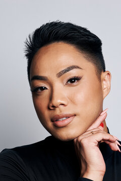 An Asian non binary young male model wears glamorous makeup