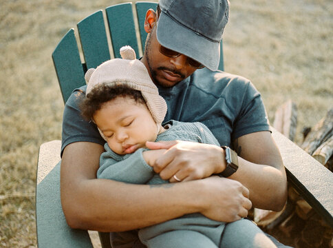 A Father Holding His Sleeping Son Outdoors