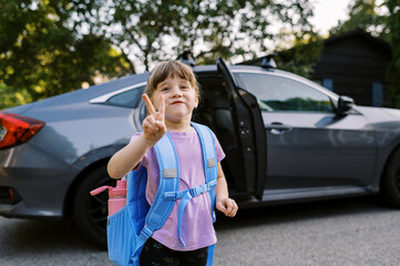 Happy little school girl with backpack on and a big smile on her face