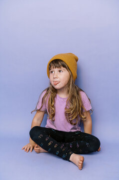 Little Happy Girl With Bangs And Long Curly Hair In A Yellow Beanie