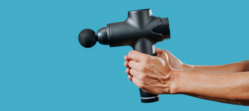 man with a massage gun, panoramic format