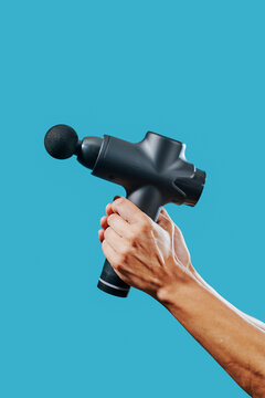man grabs a massage gun