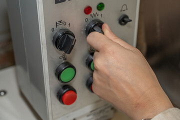 Mains sur un bouton de contrôle d'une machine industrielle marche arrêt