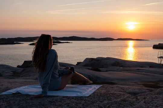 A beautiful young woman enjoys the sunset.