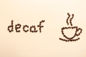 Cup of coffee and word Decaf made with beans on beige background, flat lay