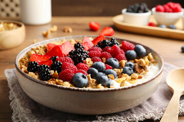 Healthy muesli served with berries on wooden table, closeup