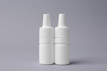 Bottles of medical drops on grey background