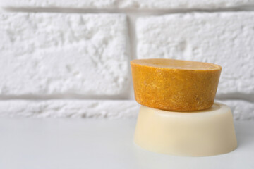 Orange solid shampoo bars on white table, closeup. Space for text