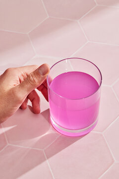 Hand holding a pink energy drink