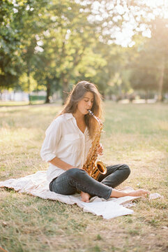 woman in a park with a saxophone