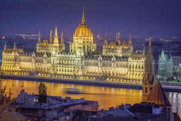 Fototapeta na wymiar Parliament illuminated and Danube River at dramatic evening, Budapest, Hungary