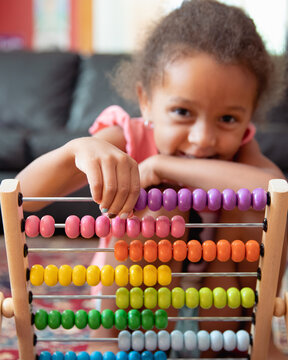 A child playing with a rainbow coloured abacus