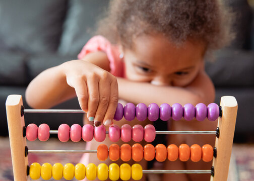A child playing with a rainbow coloured abacus