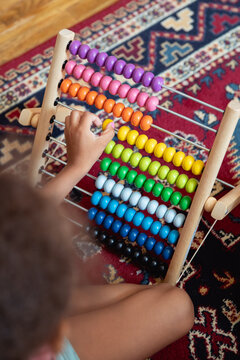 A child playing with a rainbow coloured abacus