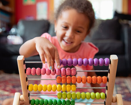 A child playing with a rainbow coloured abacus