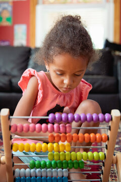 A child playing with a rainbow coloured abacus