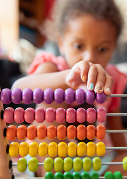 A child playing with a rainbow coloured abacus