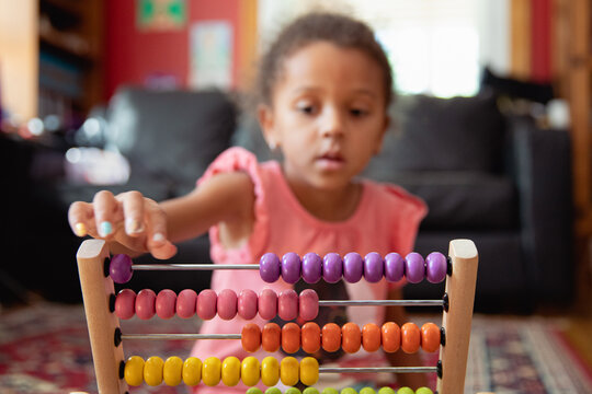 A child playing with a rainbow coloured abacus
