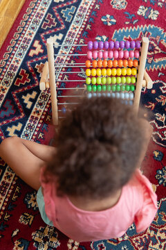 A child playing with a rainbow coloured abacus