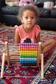 A child playing with a rainbow coloured abacus