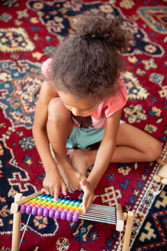 A child playing with a rainbow coloured abacus