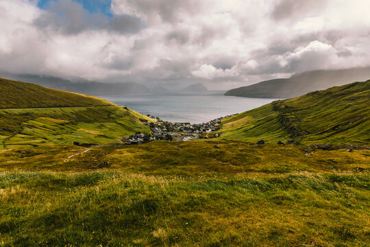 Coastal Village Among Green Mountains In The Faroe Islands