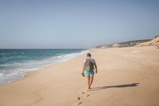 young backpacker walking on the beach