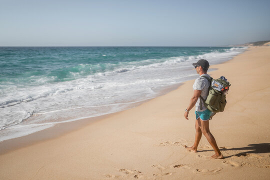 young backpacker walking on the beach